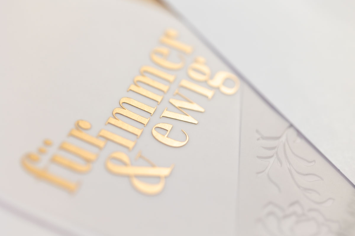 Hochwertige Hochzeitspapeterie mit Goldfolie und floral geschnittenem Transparentpapier. Der Schriftzug "für immer und ewig" ist zu lesen.